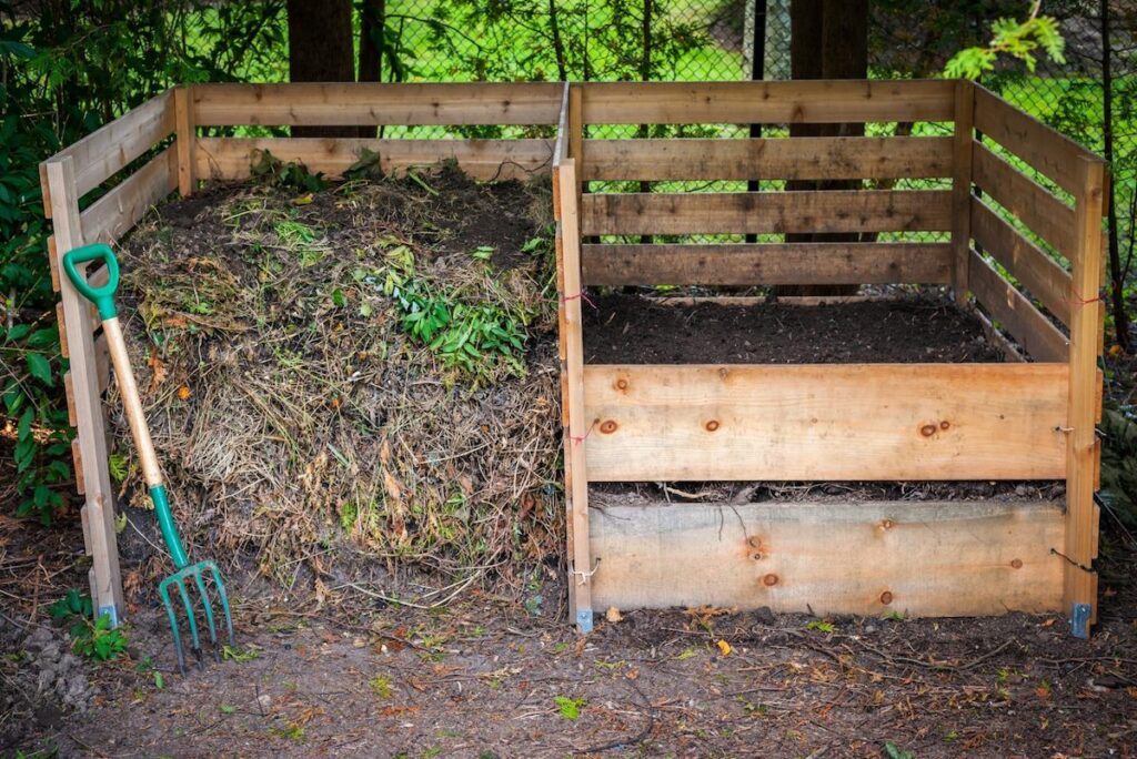 Large cedar wood compost boxes with composted soil and yard waste for backyard composting